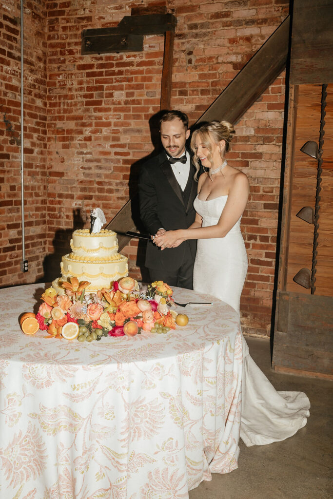 Bride and groom cut cake at Empire Mills wedding reception.